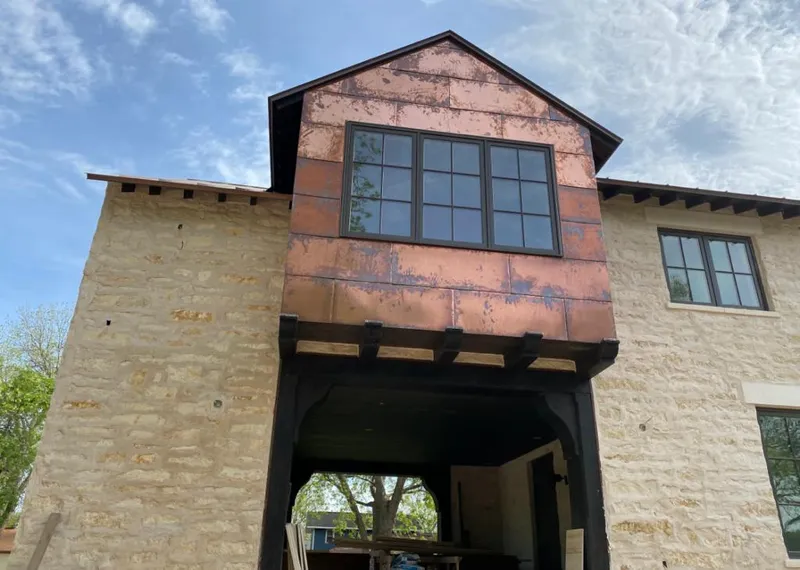 Copper metal panel facade on a stone building for Skylight Installation in Lely Resort